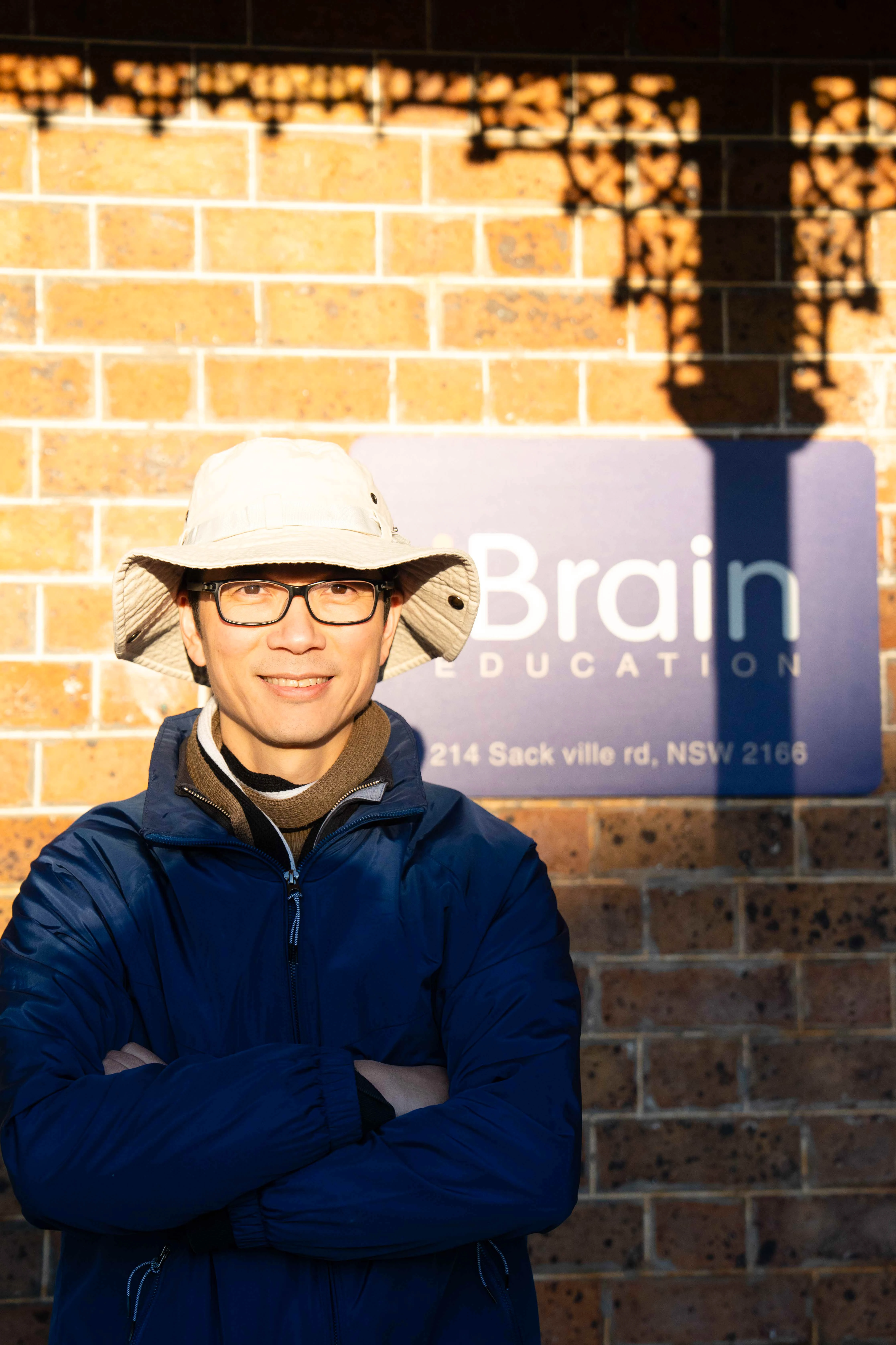 Hung Nguyen standing in front of an Ibrain Education sign